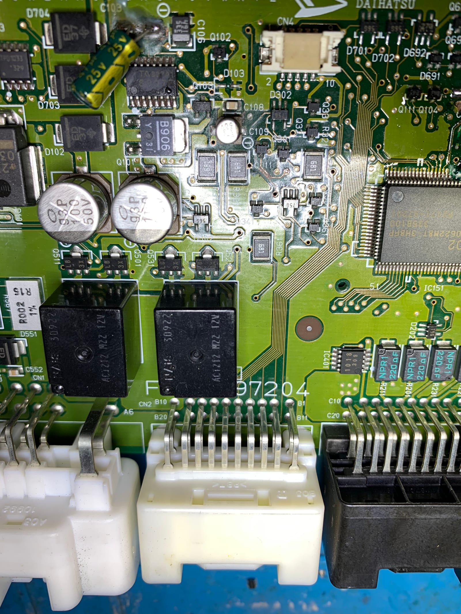 Full board view of the Daihatsu ECU showing the MCU, relays and aluminium electrolytic capacitors before capacitor replacement