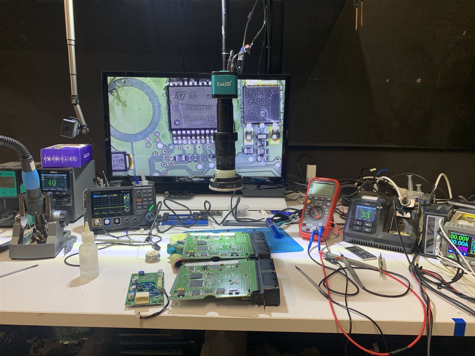 CQ Electronics workbench with a Hyundai Tucson Bosch ECU board under the microscope camera, the monitor showing the VN5012AK high-side driver chip